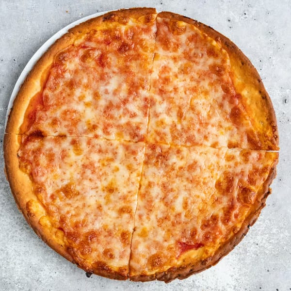 A whole cheese pizza from Cousins Pizza, cut into four slices, on a white plate.